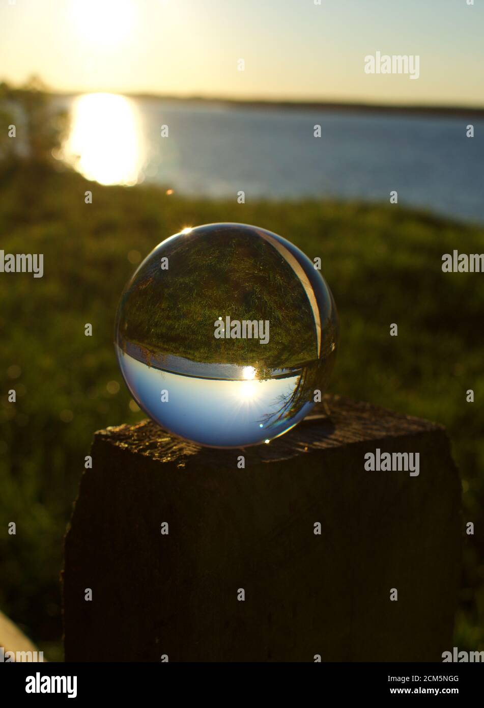 Reflection of sunset over water in a crystal ball Stock Photo - Alamy