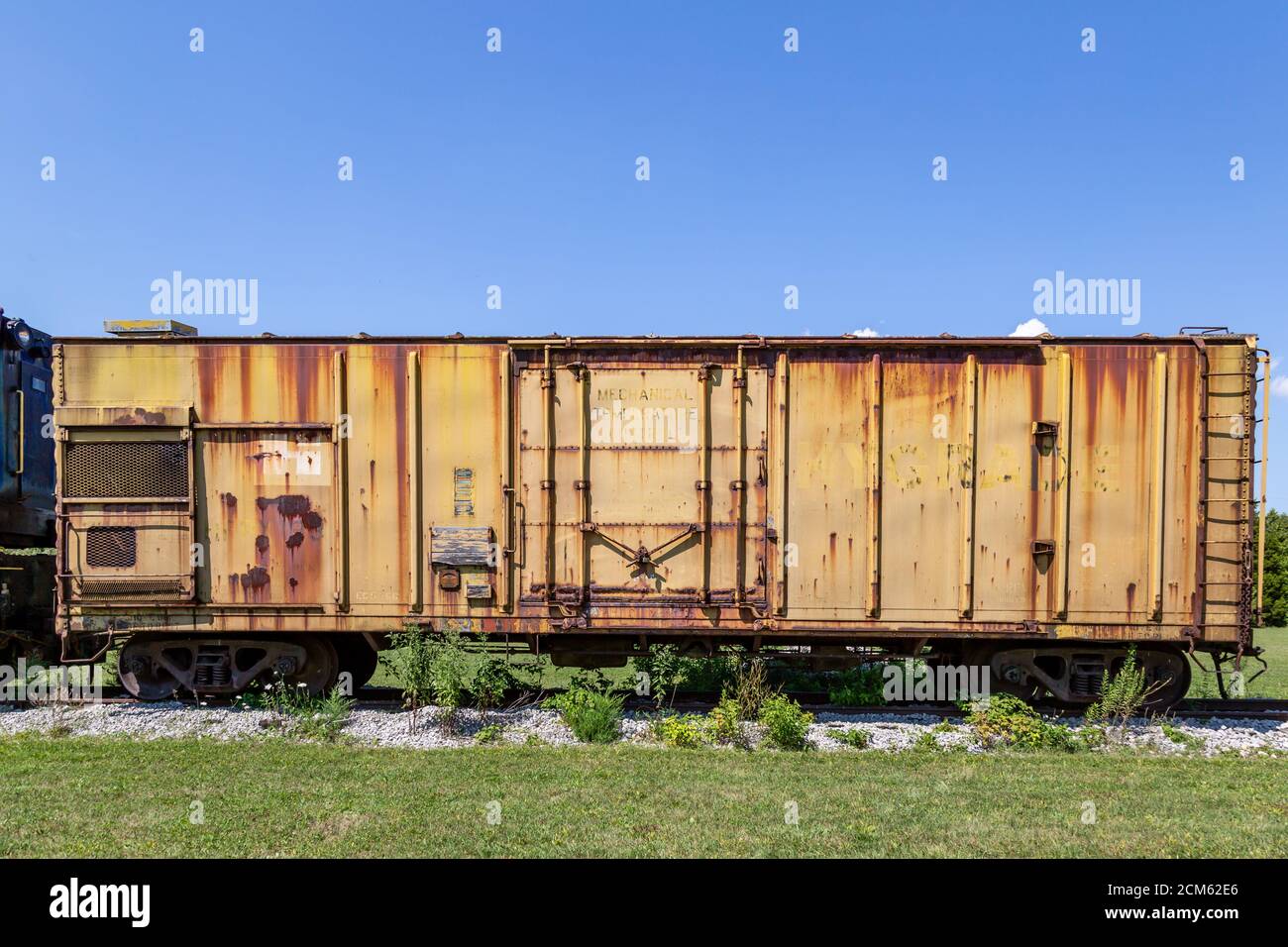 An antique yellow boxcar is on display outside the Fort Wayne Railroad