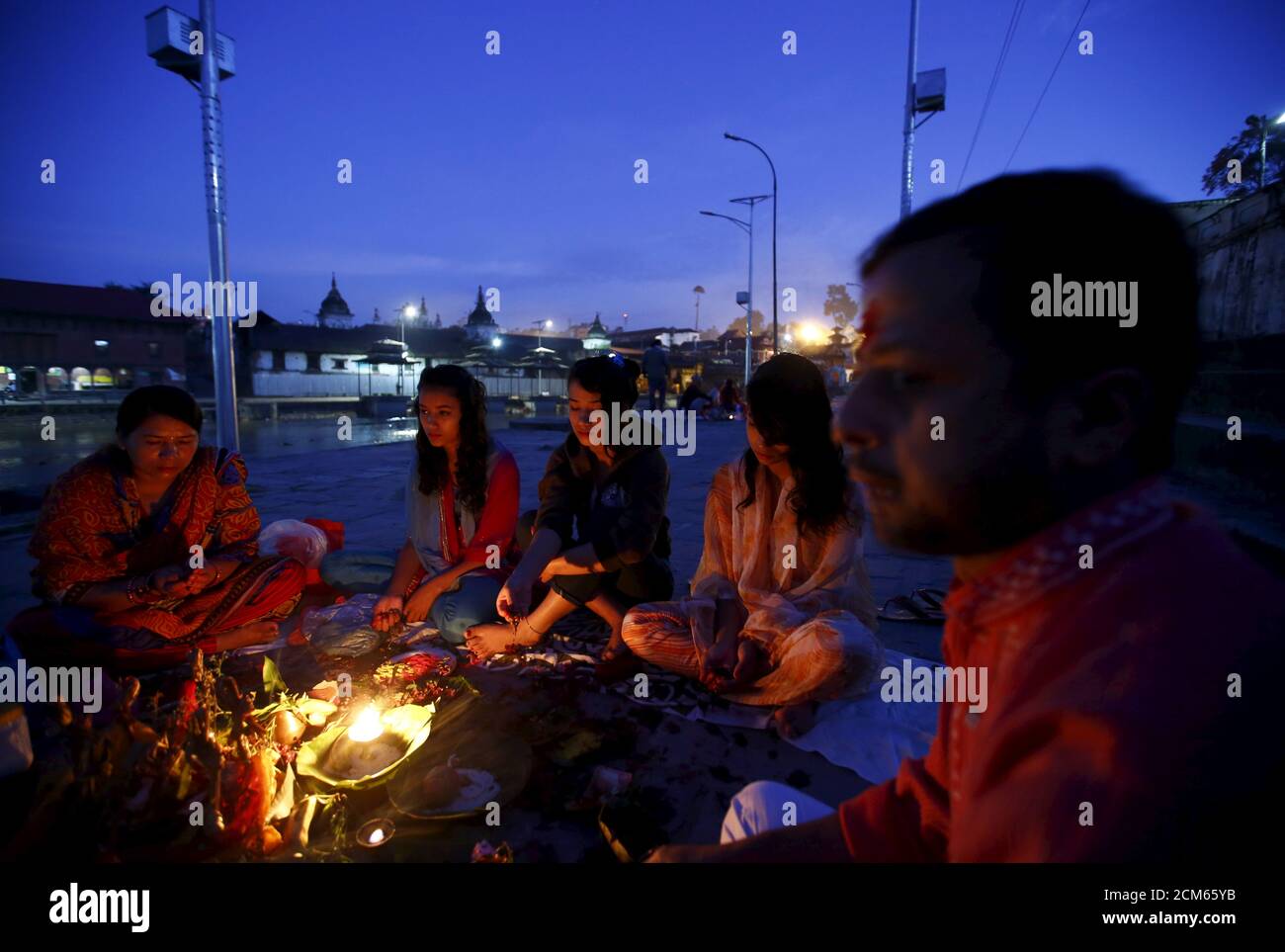 Nepalese women offer prayers along the bank of the Bagmati River, during the Rishi Panchami festival, in Kathmandu, Nepal September 18, 2015. Rishi Panchami is observed on the last day of Teej when women worship Sapta Rishi (Seven Saints) to ask for forgiveness for sins committed during their menstrual periods throughout the year. The Hindu religion considers menstruation as a representation of impurity and women are prohibited from taking part in religious practices during their monthly menstruations. REUTERS/Navesh Chitrakar Stock Photo