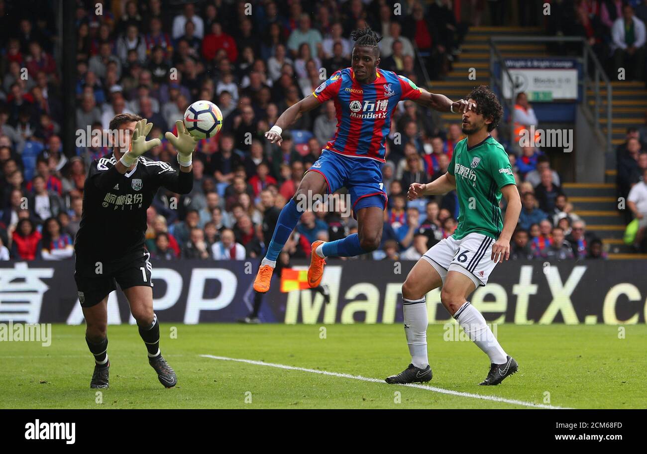 Soccer Football - Premier League - Crystal Palace vs West Bromwich Albion - Selhurst Park, London, Britain - May 13, 2018   West Bromwich Albion's Ben Foster collects the ball as Crystal Palace's Wilfried Zaha pressures   REUTERS/Hannah McKay    EDITORIAL USE ONLY. No use with unauthorized audio, video, data, fixture lists, club/league logos or "live" services. Online in-match use limited to 75 images, no video emulation. No use in betting, games or single club/league/player publications.  Please contact your account representative for further details. Stock Photo