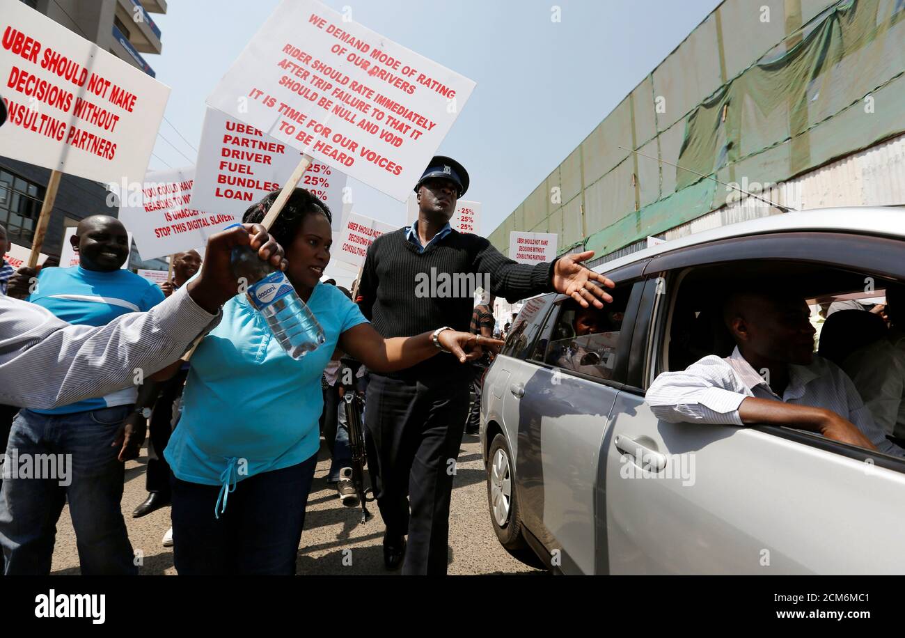 A policeman intervenes as Kenyan taxi drivers signed up to ride-hailing service Uber [UBER.UL] attempt to eject a passenger from one of the Uber operating taxis during a strike after the company slashed prices in the face of growing competition from similar local firms in Kenya's capital Nairobi, August 2, 2016. REUTERS/Thomas Mukoya  TPX IMAGES OF THE DAY Stock Photo