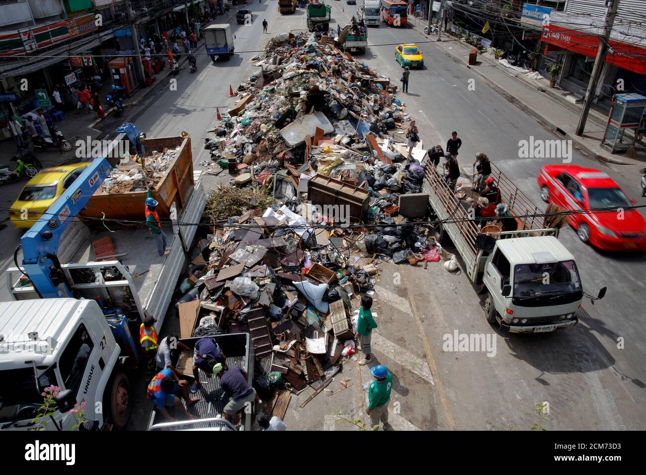 Workers clean large pile of trash left after flood waters receded from a  district in Bangkok during a "big cleaning day" November 20, 2011. The  flooding started in late July in the