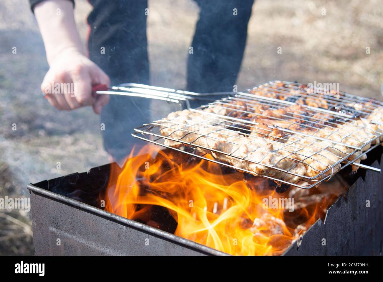 Chicken Wings On Grill, Man cooking meat on barbecue grill outdoors, closeup Stock Photo