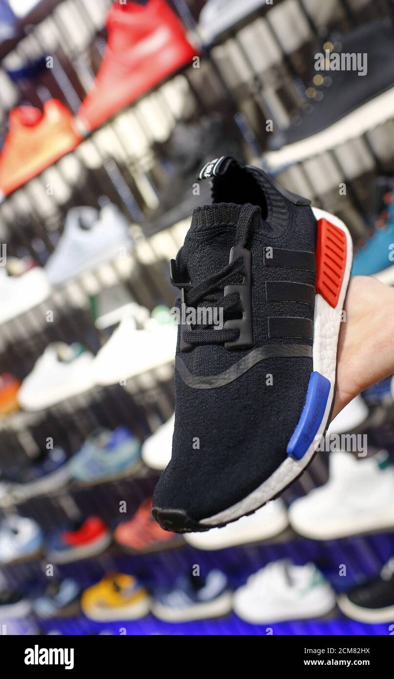 A shop assistant presents the new Adidas NMD model at the flagship store in  Berlin, Germany, January 20, 2016. A combination of new and retro sneaker  styles will keep driving growth at