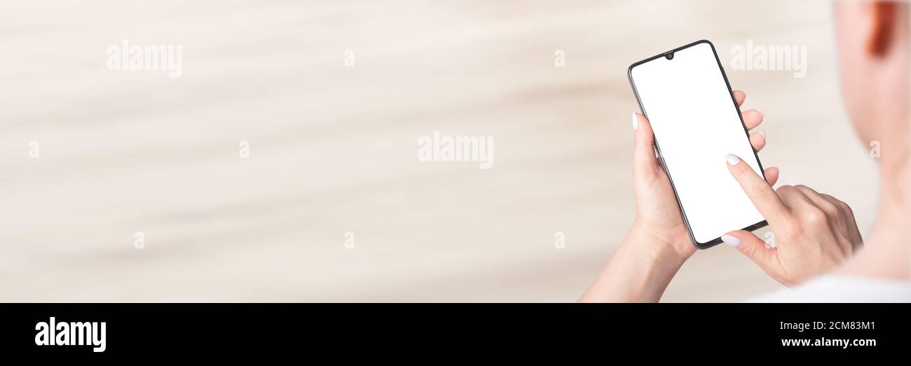 Mockup image of woman's hands holding modern cell mobile phone with blank screen, indoor, banner Stock Photo