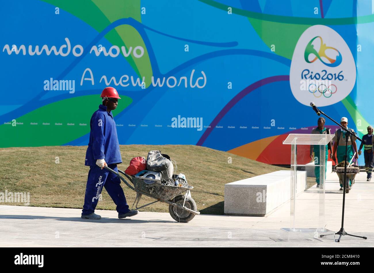 A Worker Walks Past A Microphone Where Thomas Bach President Of The International Olympic Committee Ioc And Rio De Janeiro S Mayor Eduardo Paes Are Going To Hold Speeches During Their Visit To A Worker Walks Past A Microphone Where Thomas Bach President Of The International Olympic Committee Ioc And Rio De Janeiro S Mayor Eduardo Paes Are Going To Hold Speeches During Their Visit To