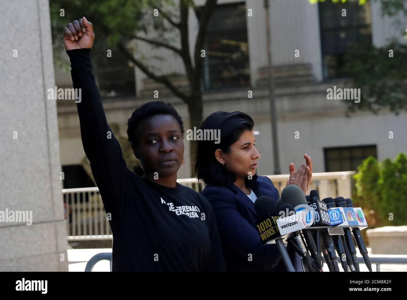 Patricia Okoumou raises her hand in the air after leaving federal court from her arraignment, a day after authorities say she scaled the stone pedestal of the Statue of Liberty to protest U.S. immigration policy, and speaking to the media in Manhattan, New York, U.S., July 5, 2018.  REUTERS/Shannon Stapleton Stock Photo