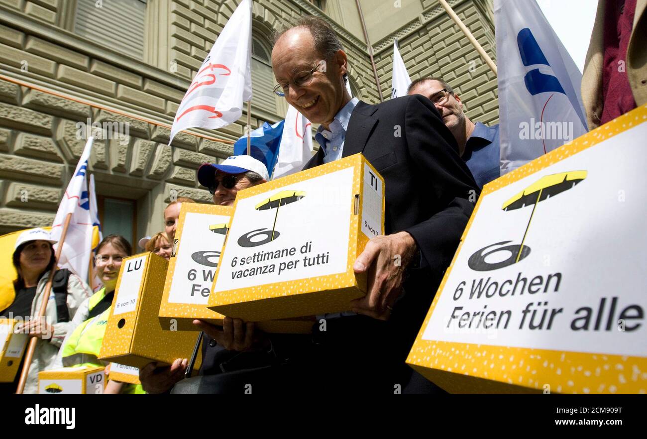 Members of different unions and national councillor Meinrado Robbiani (C) carry boxes of a signed petition for the initiative 'six weeks holiday for everyone' (6 Wochen Ferien fuer alle) outside the parliament building in Bern June 26, 2009. Some 125,000 signatures were collected from the 26 cantons of the Alpine country.  REUTERS/Pascal Lauener   (SWITZERLAND POLITICS) Stock Photo