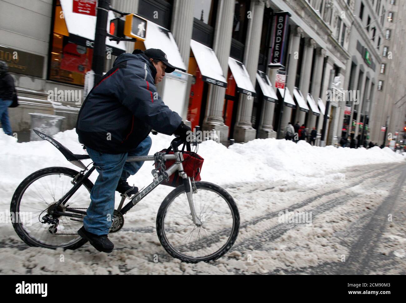 A delivery person rides his bike in the snow in New York's financial district, January 27, 2011. The Northeast dug out of yet another winter storm on Thursday that pummelled the region with between six and 19 inches of snow overnight. REUTERS/Brendan McDermid (UNITED STATES - Tags: ENVIRONMENT BUSINESS TRANSPORT) Stock Photo