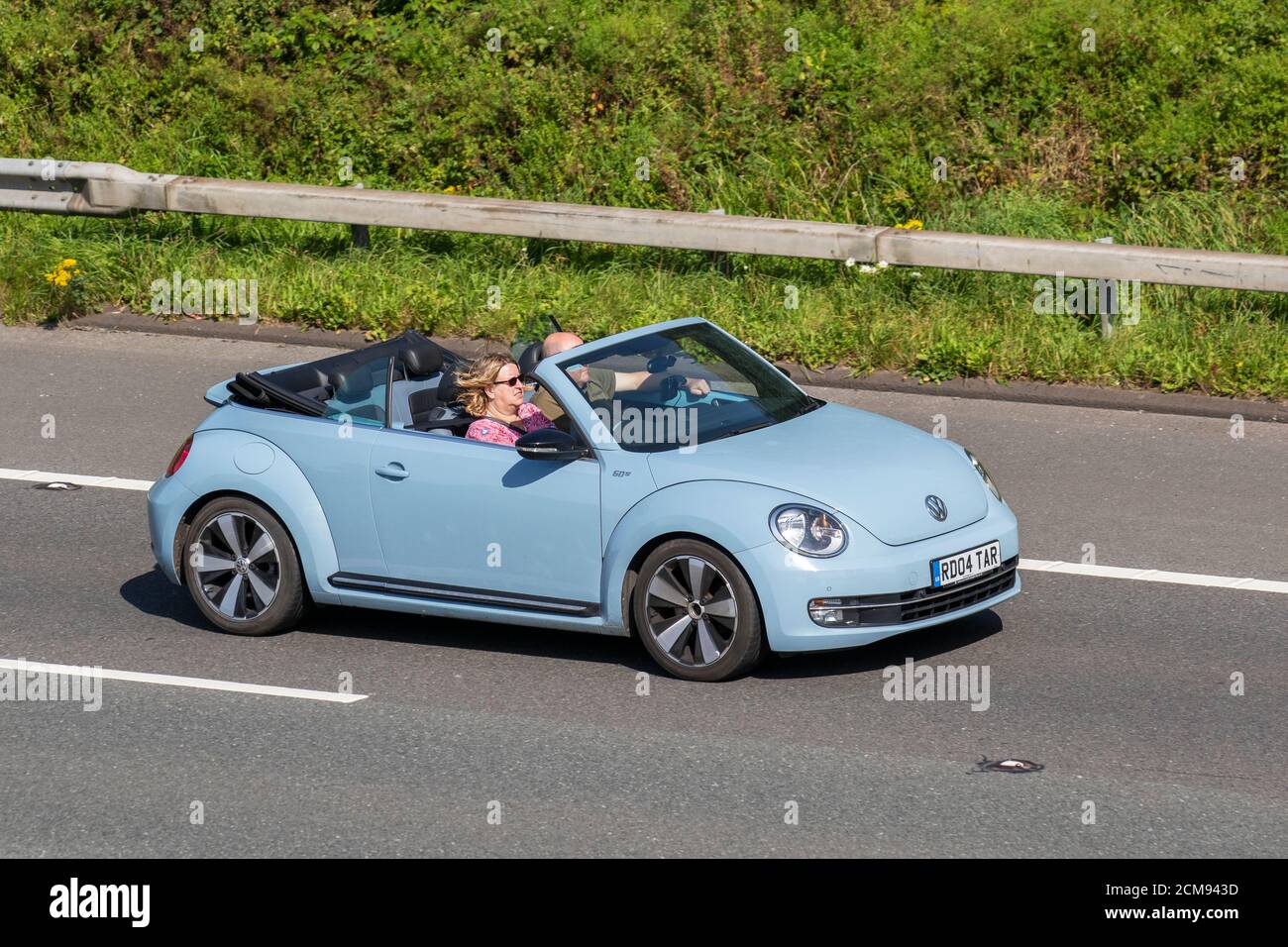 2013 blue VW Volkswagen Beetle 60S Edition; Vehicular traffic moving vehicles, cars driving vehicle on UK roads, motors, motoring on the M6 motorway highway network. Stock Photo