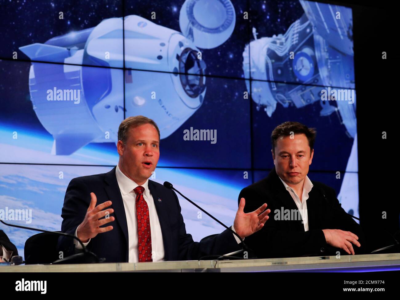 SpaceX founder Elon Musk listens to NASA Administrator Jim Bridenstine at a post-launch news conference after a SpaceX Falcon 9 rocket, carrying the Crew Dragon spacecraft, lifted off on an uncrewed test flight to the International Space Station from the Kennedy Space Center in Cape Canaveral, Florida, U.S., March 2, 2019. REUTERS/Mike Blake Stock Photo
