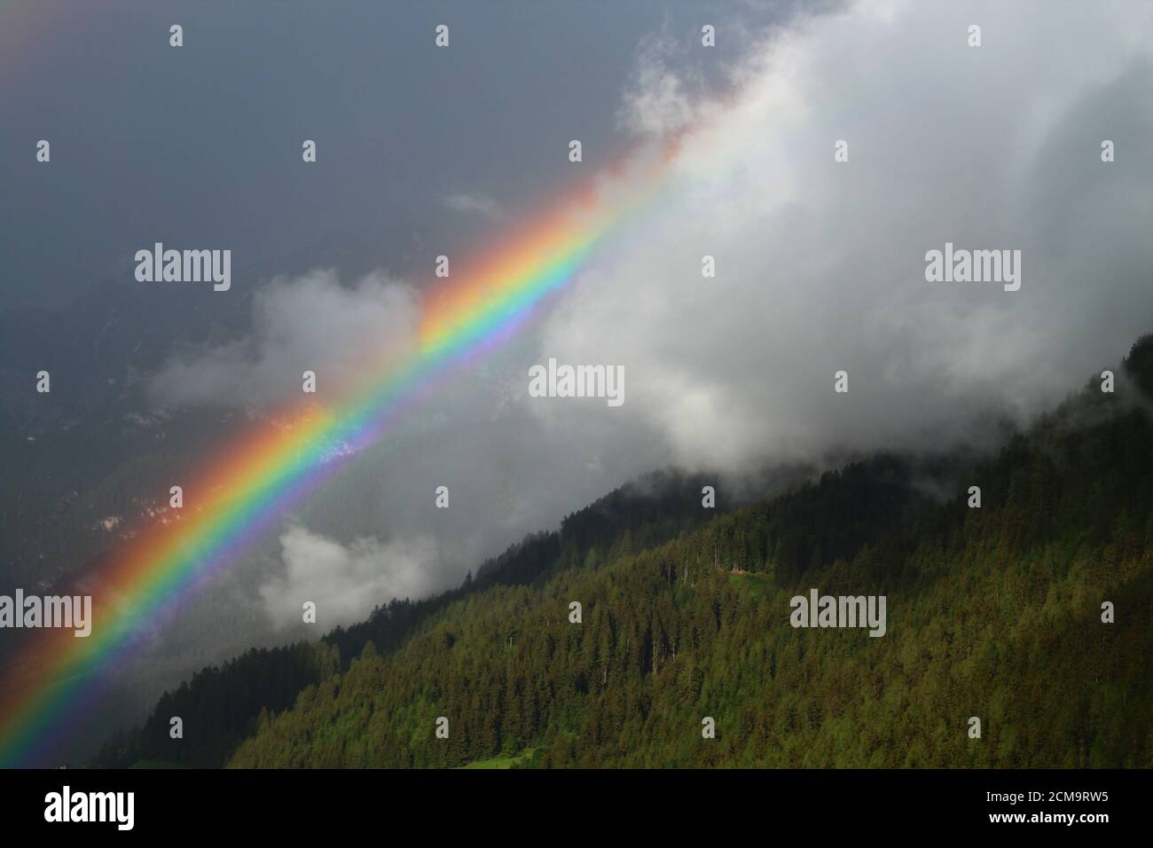 Beautiful Rainbow above the forest of the Stubai Valley, Tyrol, Austria Stock Photo