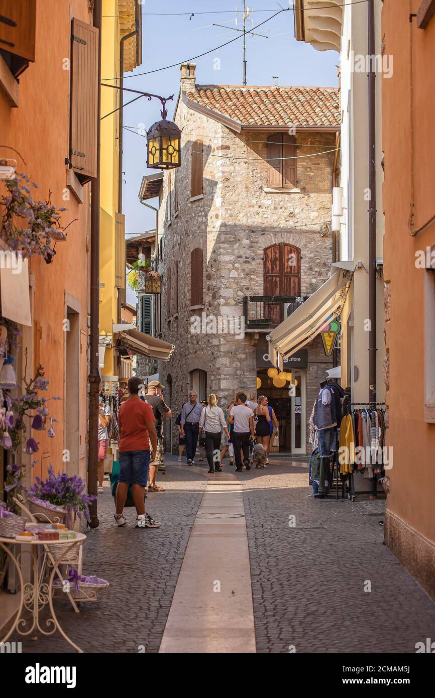 Alley with people and tourists walking in Lazise in Italy Stock Photo