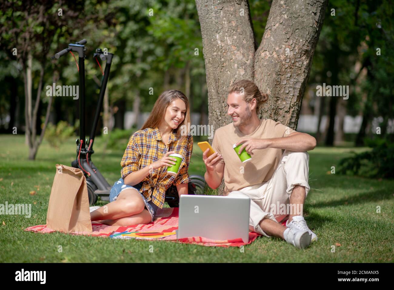 Couple sitting under tree hi-res stock photography and images - Alamy