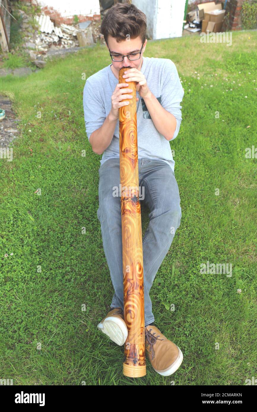 Teenage Caucasian boy playing didgeridoo Stock Photo