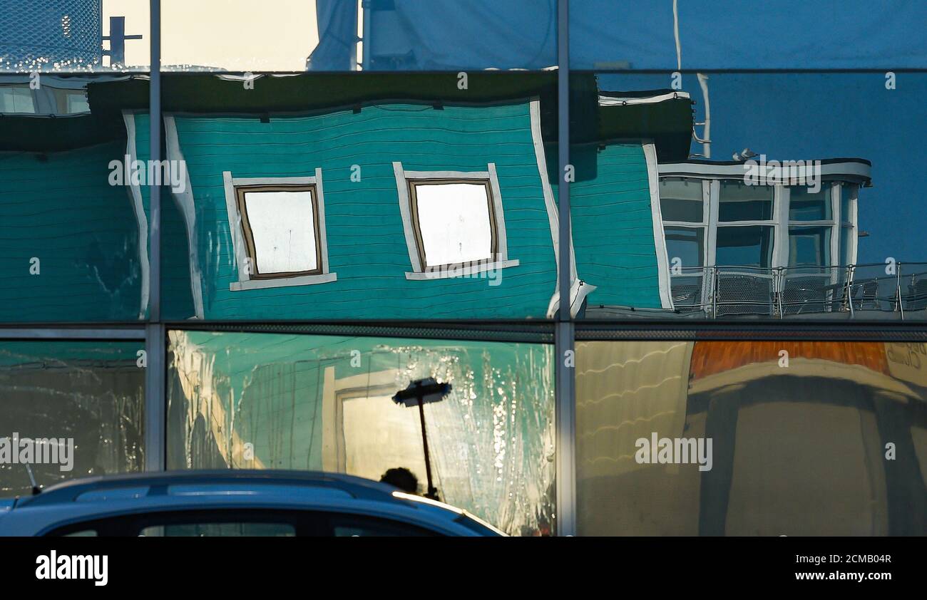 Brighton UK 17th September 2020 - A beautiful sunny morning to wash the Brighton i360 tower windows with the Upside Down House reflected in the glass as the warm weather continues in the South East of the UK : Credit Simon Dack / Alamy Live News Stock Photo