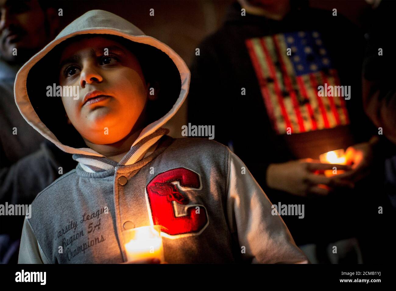 People hold candles during a vigil for victims killed in the attack by Taliban gunmen on the Army Public School in Peshawar Pakistan, in the Brooklyn borough of New York December 17, 2014. Pakistan on Wednesday began burying 132 students killed in a grisly attack on their school by Taliban militants that has heaped pressure on the government to do more to tackle an increasingly aggressive Taliban insurgency. REUTERS/Brendan McDermid (UNITED STATES - Tags: EDUCATION CRIME LAW SOCIETY CIVIL UNREST) Stock Photo