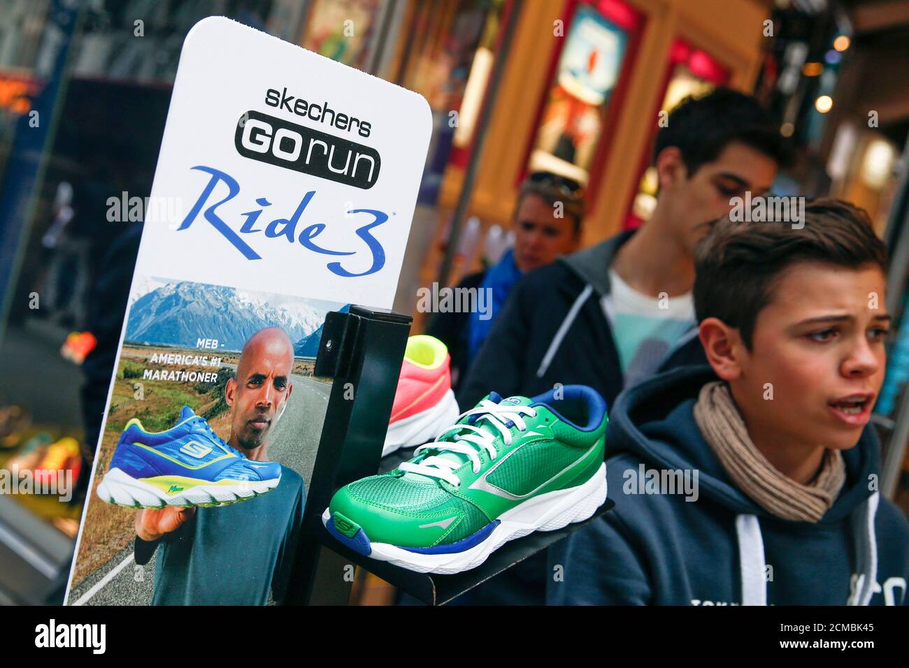 People walk by a Skechers shoe display at Times Square in New York May 2,  2014. Sport shoes maker Skechers USA Inc said on Friday it will explore  buying a stake in
