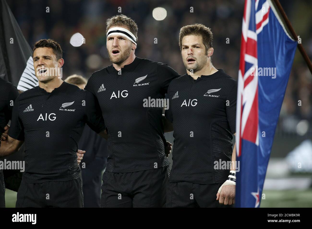 New Zealand's All Black's captain Richie McCaw (R) sings the national  anthem alongside Keiran Read (C) and Dan Carter (L) before their Bledisloe  Cup rugby match against Australia at Eden Park in