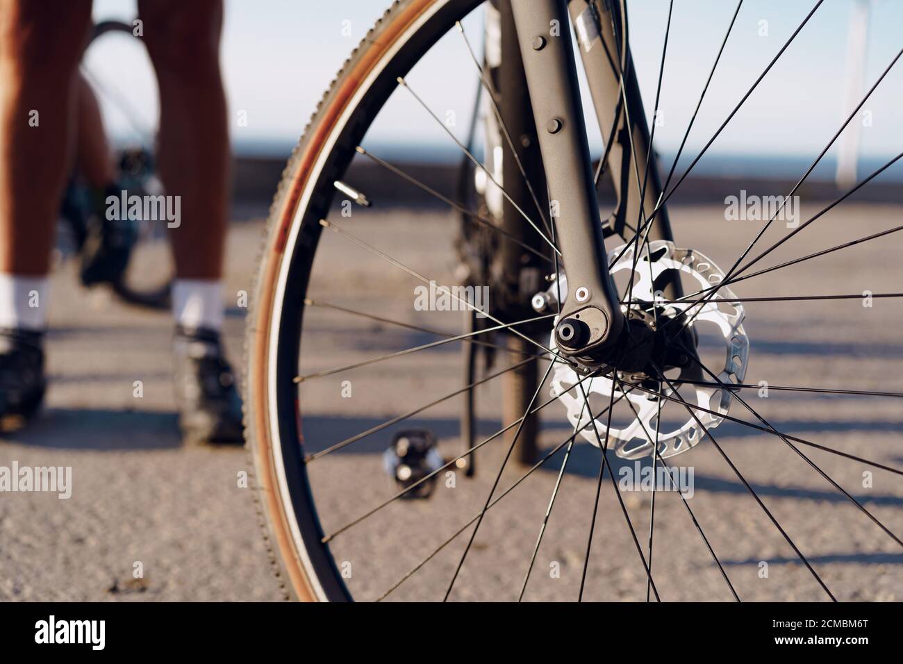 Cyclist man feet and bike wheel on coastal road Stock Photo Alamy