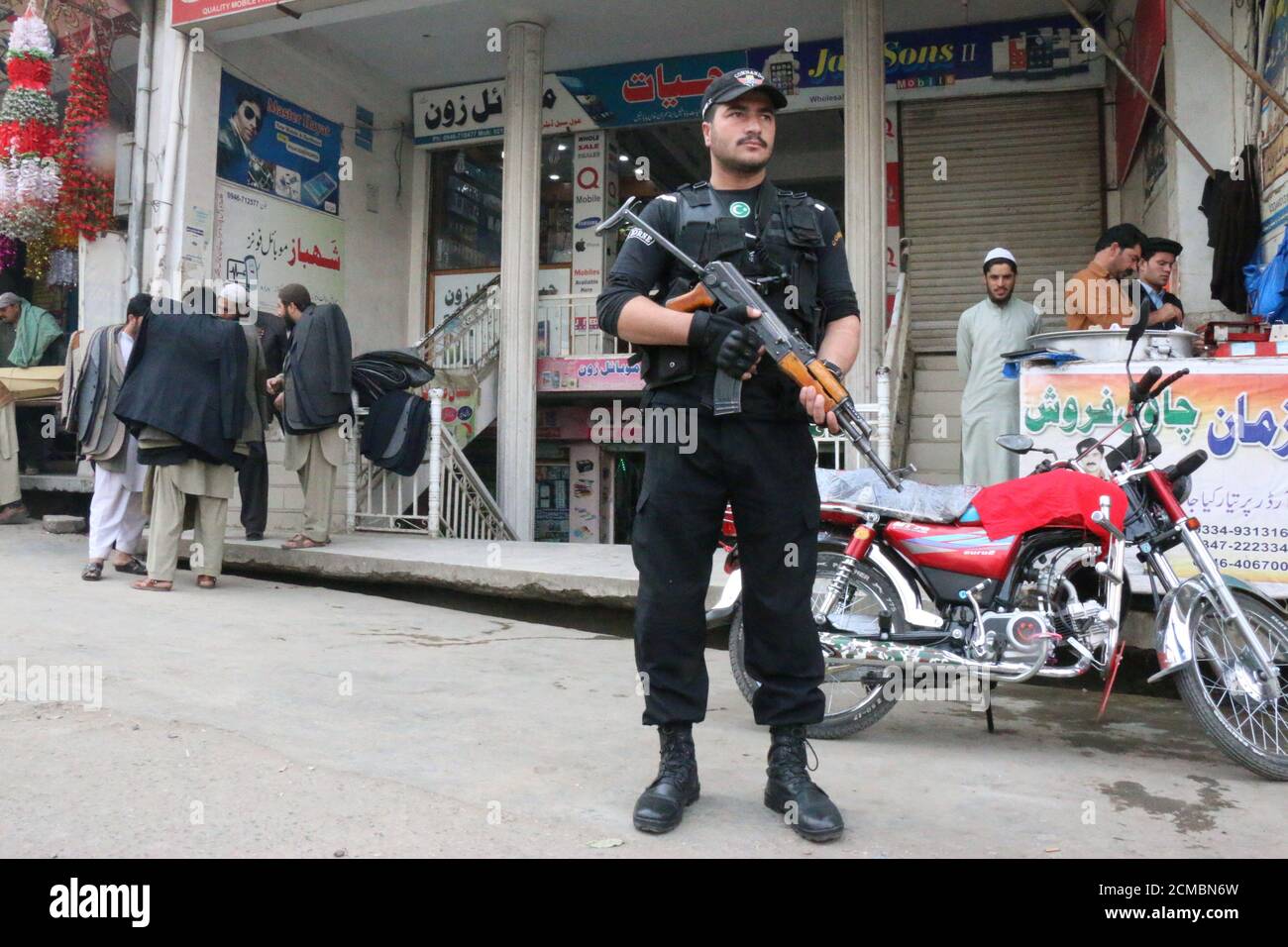 A policeman stands guard at a market in Mingora, in Swat Valley, Pakistan December 7, 2016. Picture taken December 7, 2016. REUTERS/Hazrat Ali Bacha Stock Photo