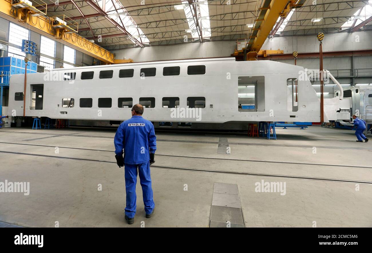 Workers prepare a carriage of a double-deck train to be lifted up during  assembling works at a Swiss Stadler Rail plant in the northeastern Swiss  village of Altenrhein April 15, 2014. Stadler