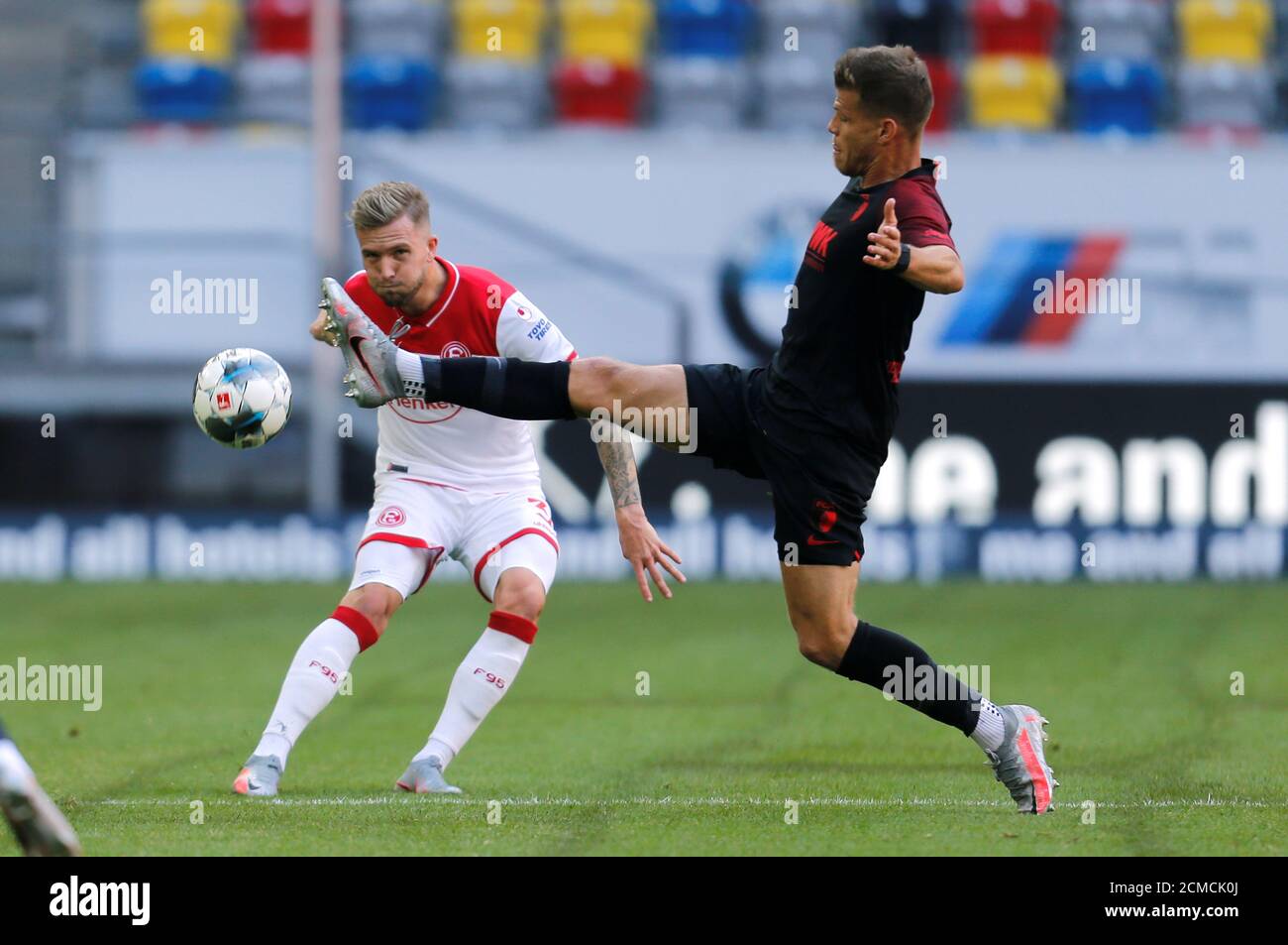 Soccer Football - Bundesliga - Fortuna Dusseldorf v FC Augsburg - Merkur Spiel-Arena, Dusseldorf, Germany - June 20, 2020  Fortuna Dusseldorf's Andre Hoffmann in action with FC Augsburg's Florian Niederlechner, following the resumption of play behind closed doors after the outbreak of the coronavirus disease (COVID-19)   REUTERS/Leon Kuegeler/Pool    DFL regulations prohibit any use of photographs as image sequences and/or quasi-video Stock Photo