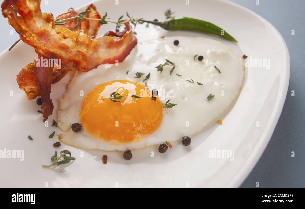 Breakfast. Fried eggs and bacon close up on an oval plate. Stock Photo