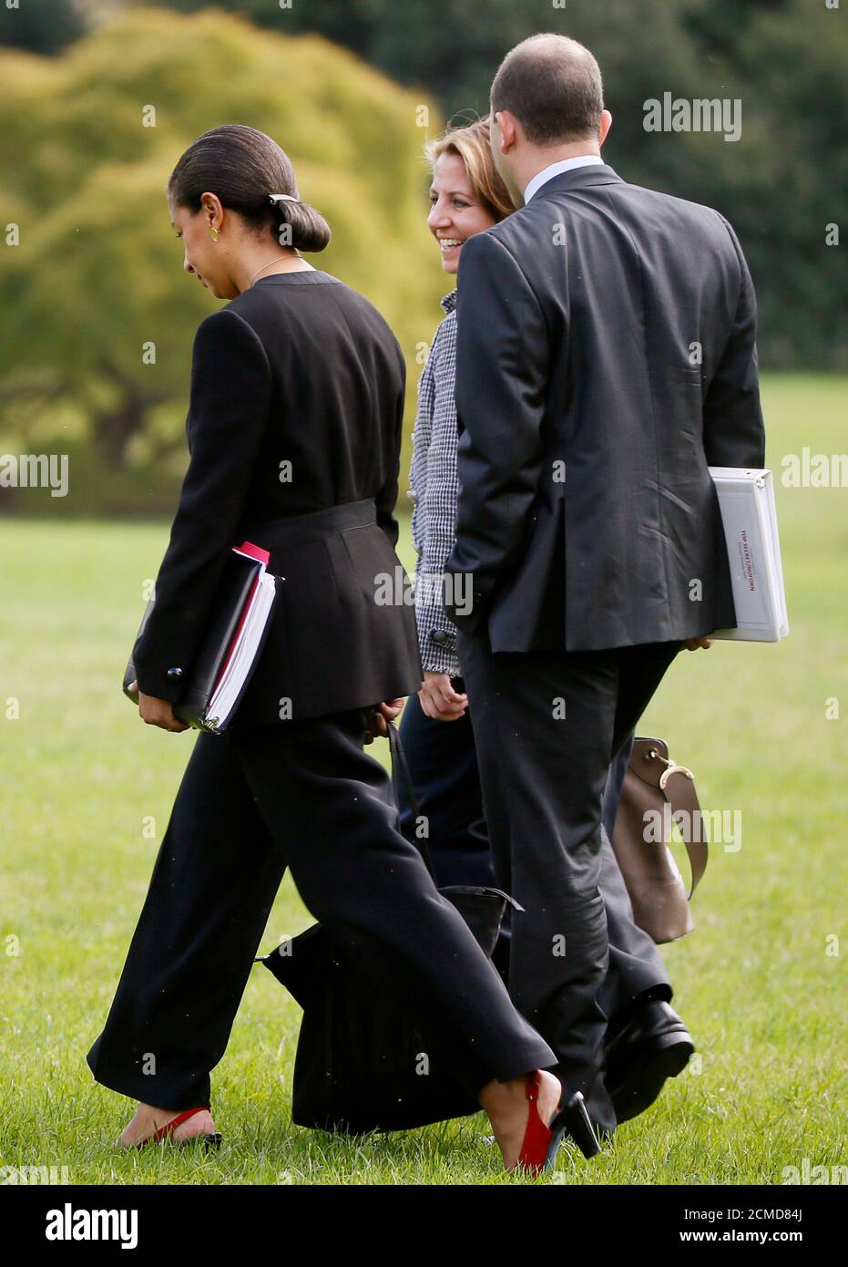 White House counter-terrorism adviser Lisa Monaco (C) talks with National Security Advisor Susan Rice (L) and Deputy National Security Advisor Ben Rhodes as they head to the Marine One helicopter with President Barack Obama (not pictured) at the White House in Washington, October 14, 2014. Monaco accompanied the President to a meeting with 20 foreign defense chiefs after meeting with New York City Mayor Bill de Blasio and NY Police Commissioner William Bratton earlier in the day to discuss the threats posed by Ebola and Islamic State. REUTERS/Jim Bourg (UNITED STATES - Tags: POLITICS) Stock Photo