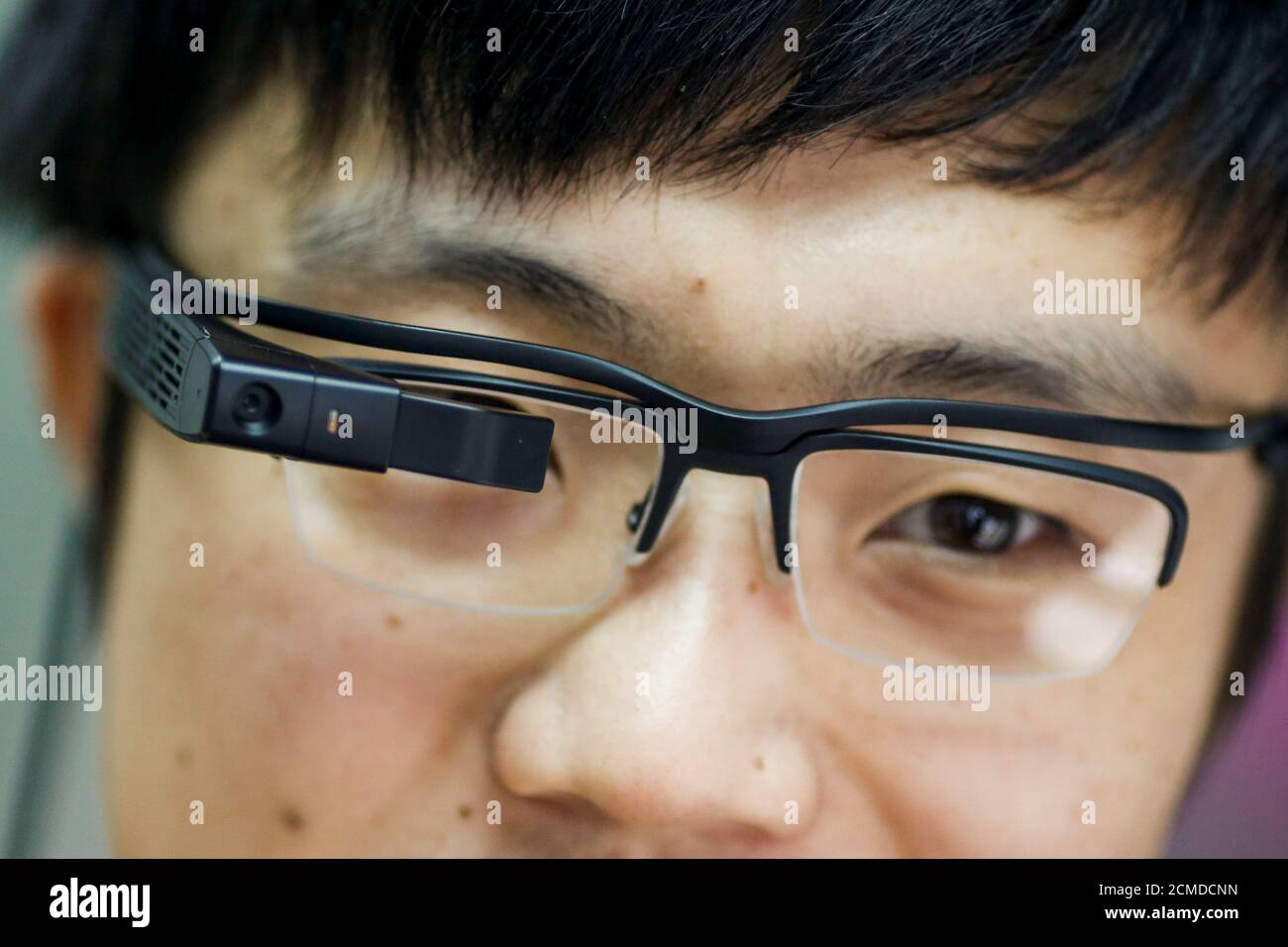 LLVision design director Tianyi Liu wears LLVision facial recognition smart  glasses as he demonstrates them at the company's office in Beijing, China  February 28, 2018. Picture taken February 28, 2018. REUTERS/Thomas Peter
