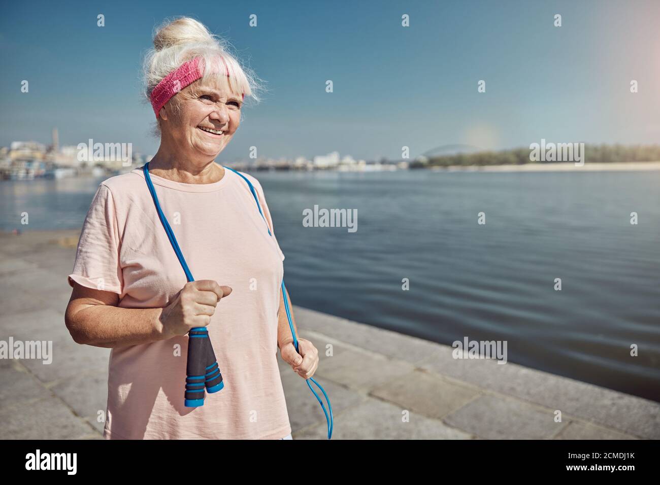 Smiling pleased elderly lady standing on the quay Stock Photo