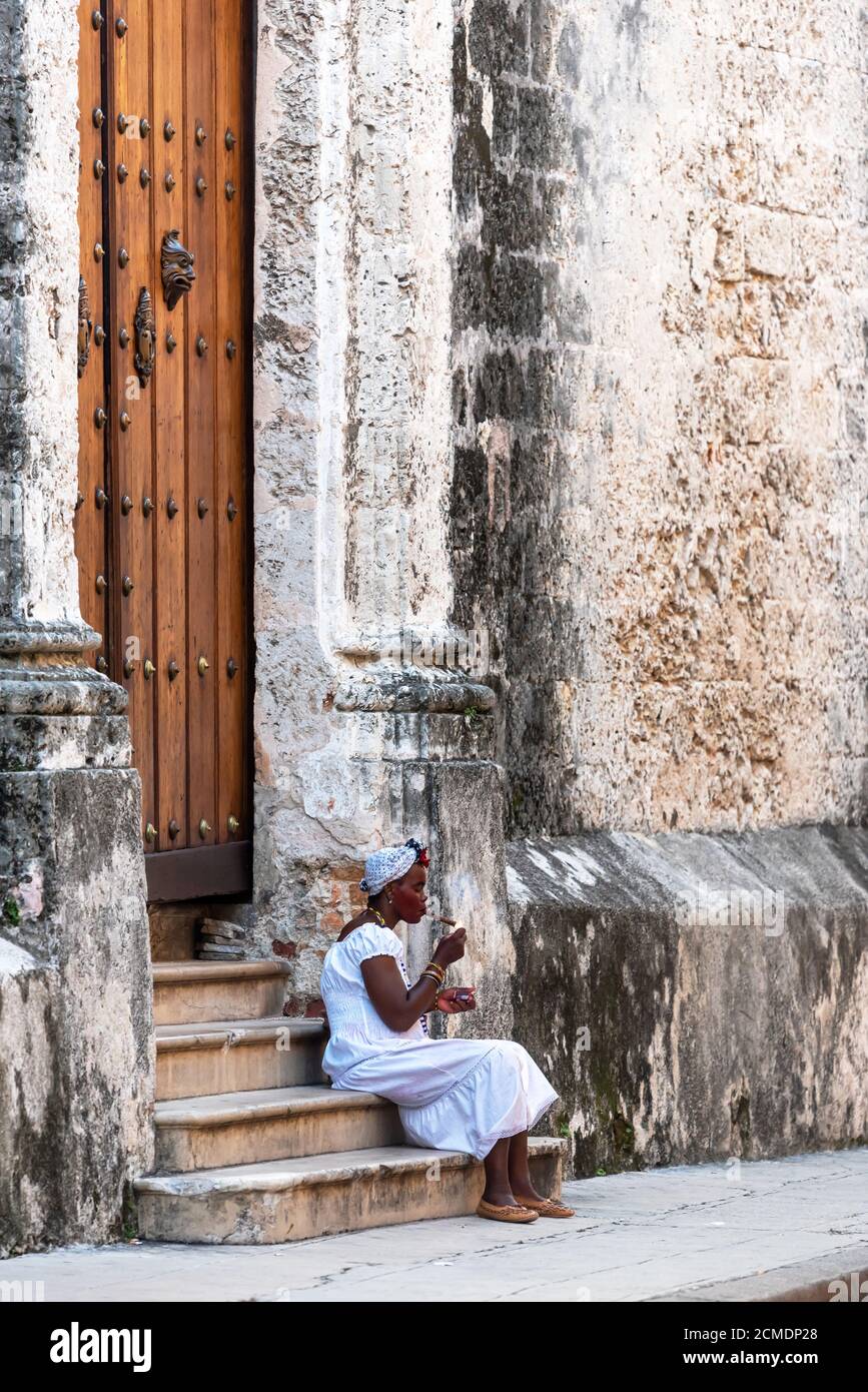 August 23, 2019: Cuban lady smoking a large cigar in La Havana. Havana, Cuba Stock Photo