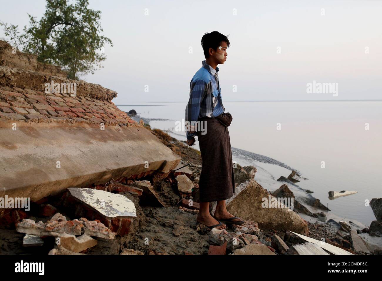 A student stands near the rubble of a school after it collapsed into the water in Ta Dar U village, Bago, Myanmar, February 6, 2020. Photo taken on February 6, 2020. REUTERS/Ann Wang Stock Photo