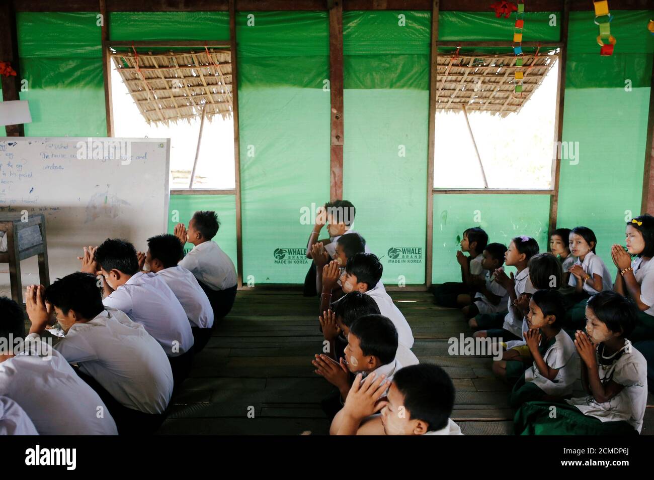 Students pray at a makeshift school in Ta Dar U village in Bago, Myanmar, February 6, 2020. Photo taken on February 6, 2020. REUTERS/Ann Wang Stock Photo