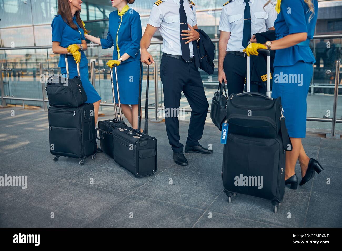 Airline workers with travel bags standing on the street Stock Photo