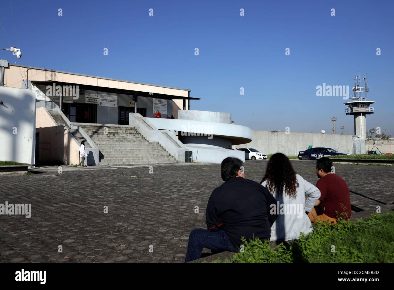 People sit near the entrance to Santa Martha Acatitla prison, where former social development minister Rosario Robles was taken into custody pending criminal proceedings in a case involving loss to taxpayers, in Mexico City, Mexico August 13, 2019. REUTERS/Luis Cortes Stock Photo