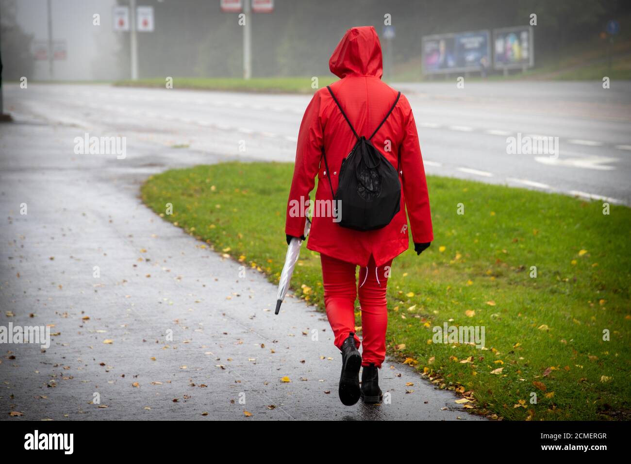 Back view of a female in a red coat walking in rain Stock Photo - Alamy
