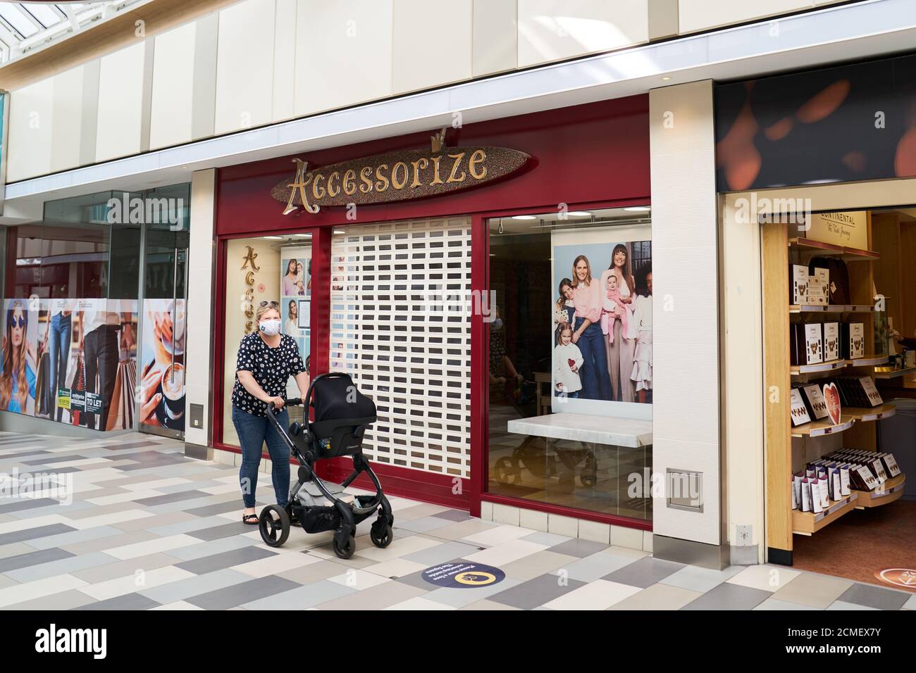 A shopper walks past a closed Accessorize store in the Atrium shopping