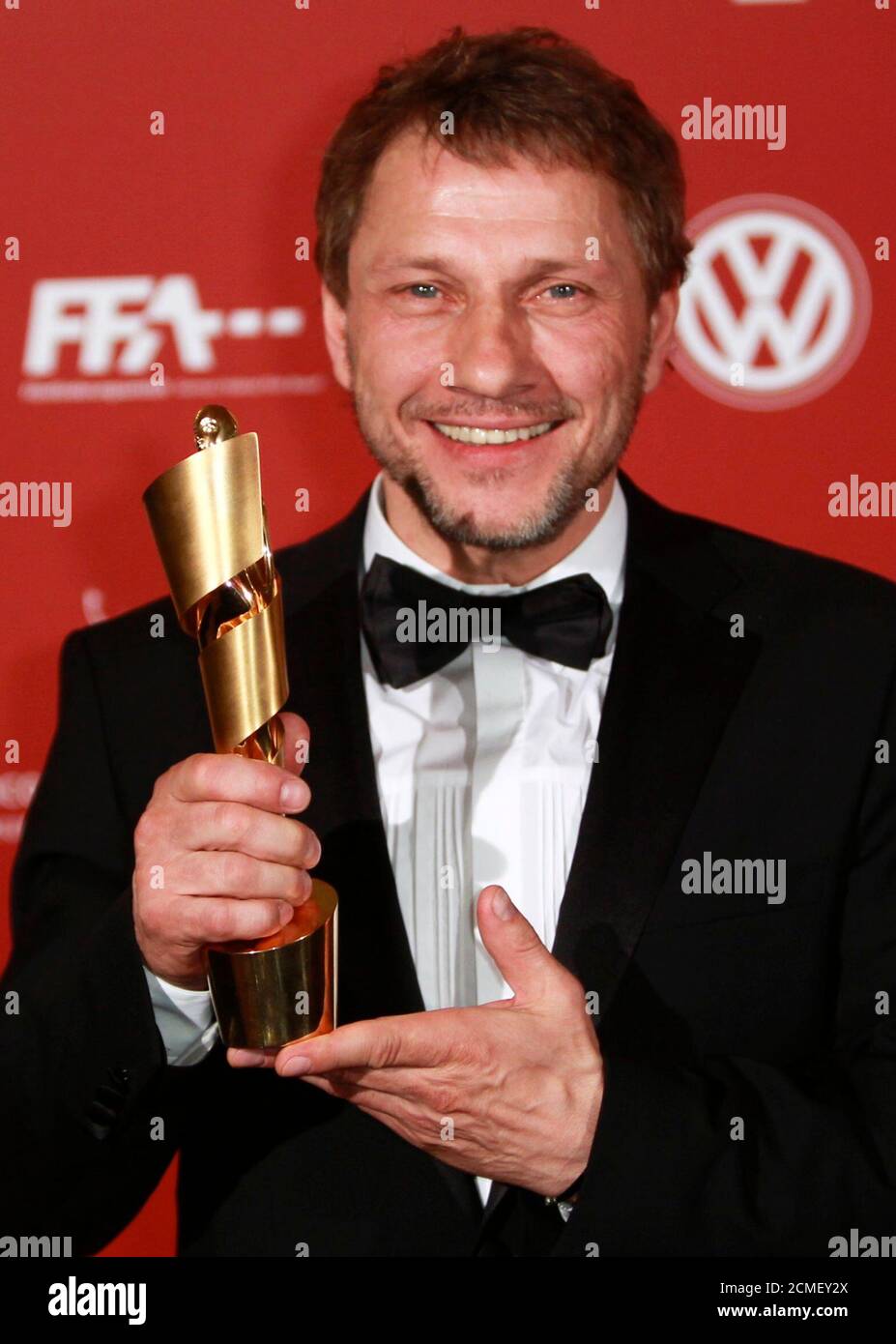 German actor Richy Mueller poses with the award for the best supporting male role in the film 'Poll' during the German Film Prize (Lola) ceremony in Berlin, April 8, 2011.        REUTERS/Thomas Peter (GERMANY  - Tags: ENTERTAINMENT SOCIETY) Stock Photo