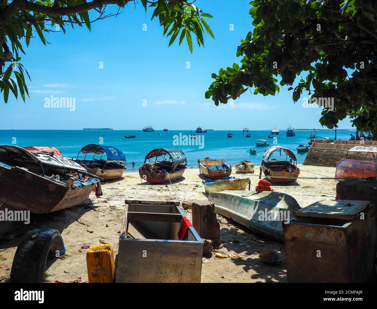 Fishing boats and crystal clear turquoise waters at stone town on the island of zanzibar. Stock Photo