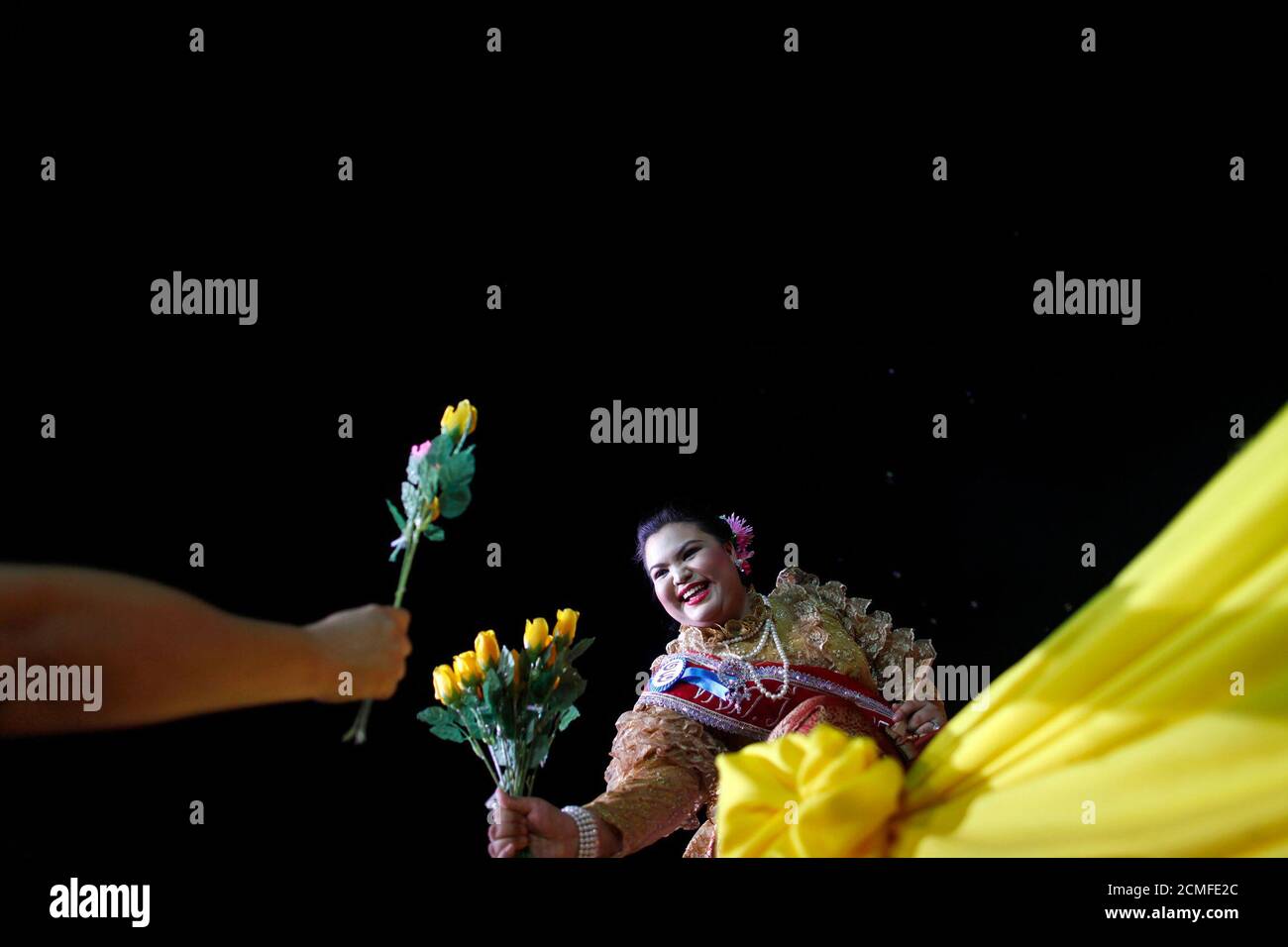 A participant in the Jumbo Queen beauty contest receives flowers while on the stage in Ayutthaya late December 19, 2009. More than 30 Thai ladies took part in the Jumbo Queen beauty contest for women over 80 kg in the world heritage site of Ayutthaya.  REUTERS/Damir Sagolj (THAILAND - Tags: SOCIETY IMAGES OF THE DAY) Stock Photo