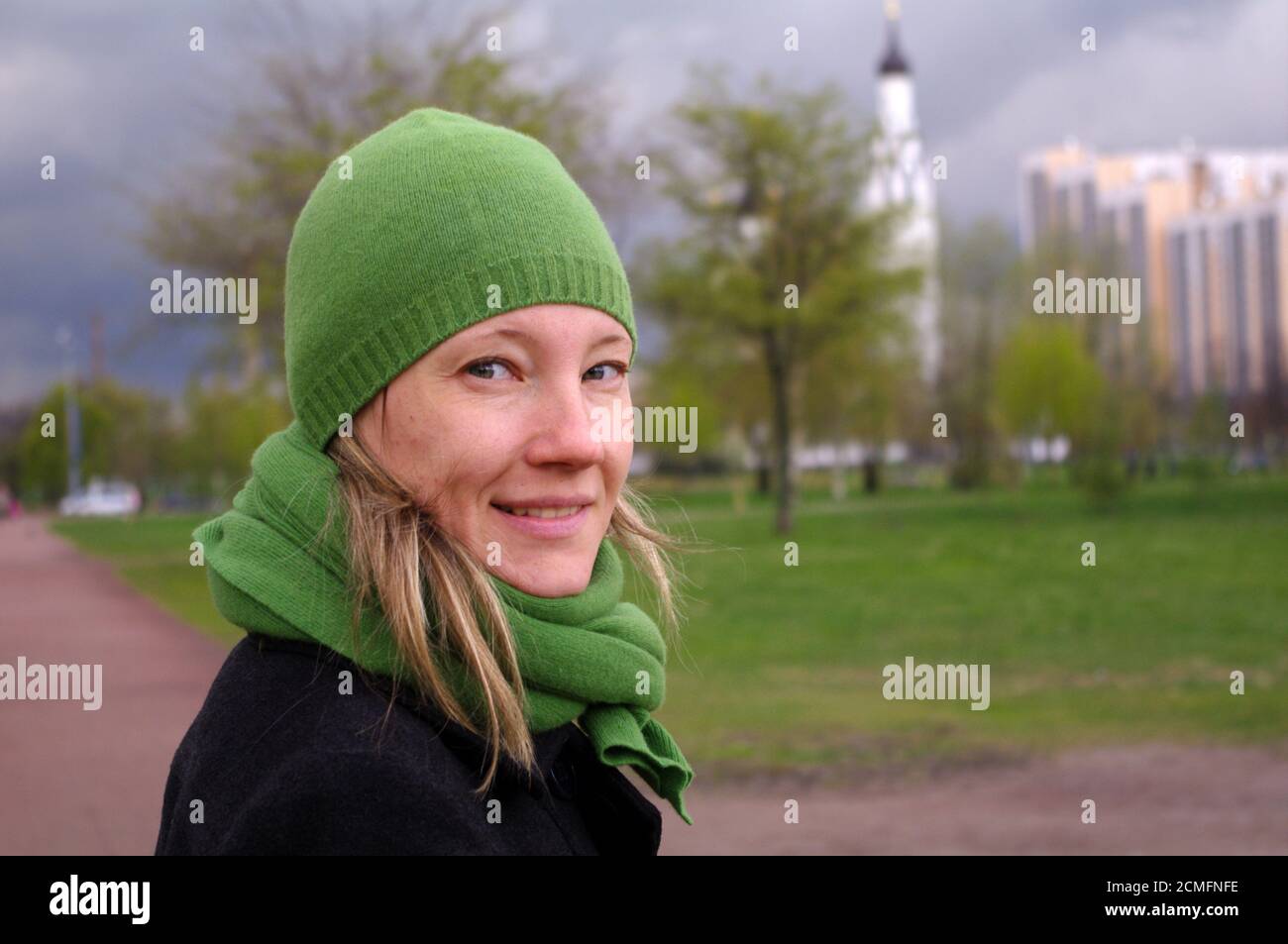 happy woman at a spring day walking on path to the church, close-up potrait Stock Photo