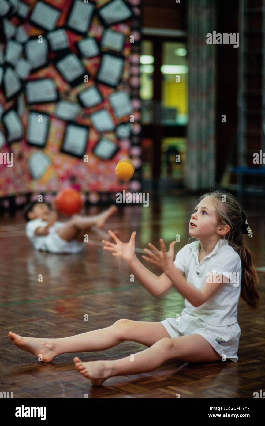 Learning ball skills in a physical education lesson in the school hall at Cottenham Park Primary School in Raynes Park, south-west London. 06 January 1994. Photo: Neil Turner Stock Photo