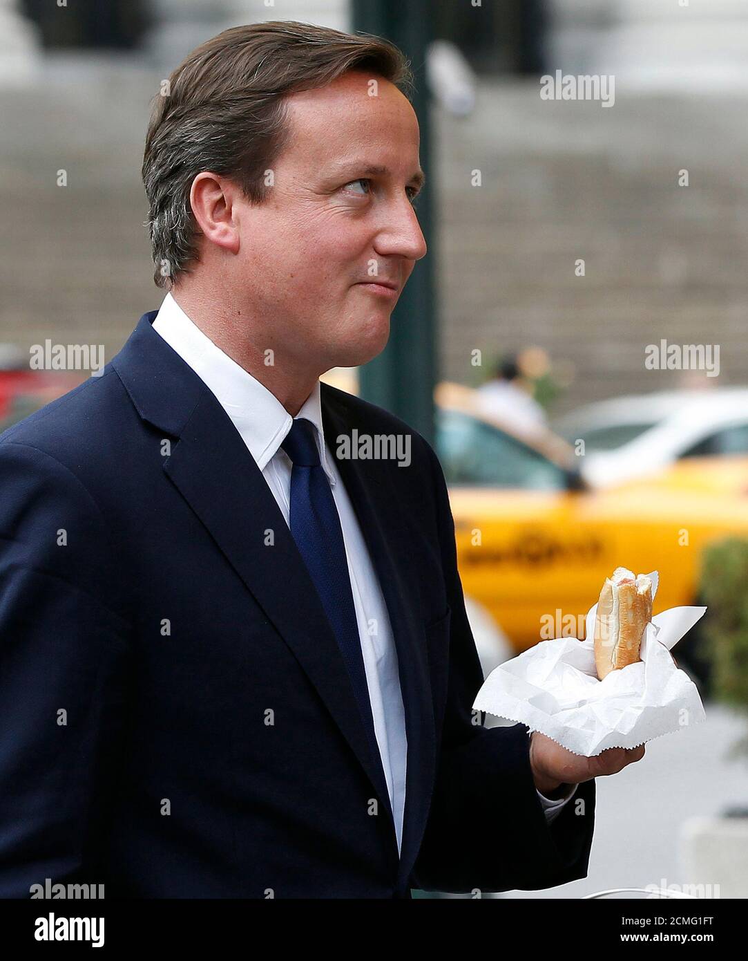 British Prime Minister David Cameron Looks Up While Eating A Hot Dog With New York City Mayor Michael Bloomberg Outside Penn Station In New York July 21 2010 Reuters Shannon Stapleton United States