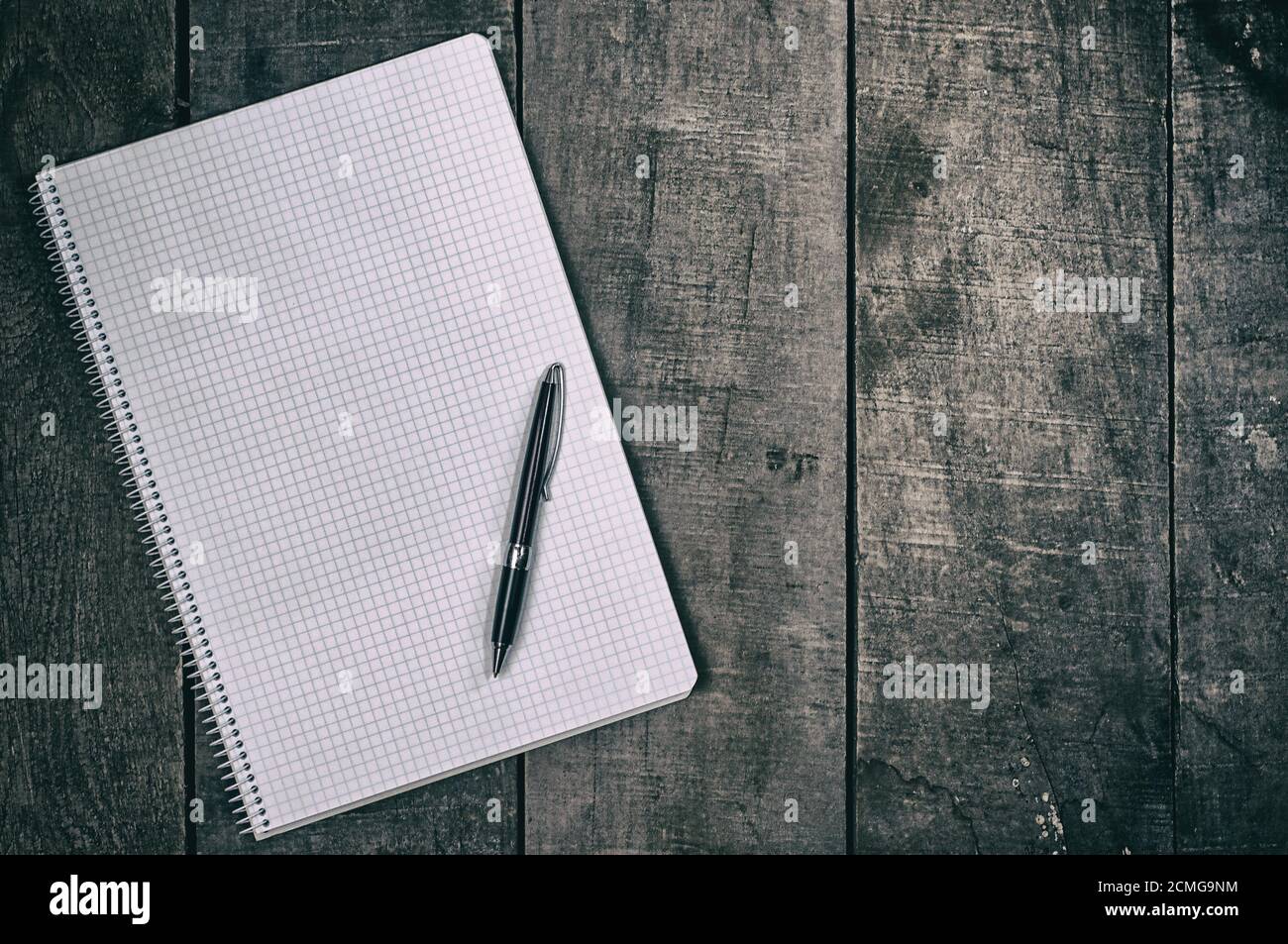Open notebook into the cell, clean sheets lying on a wooden surface Stock Photo