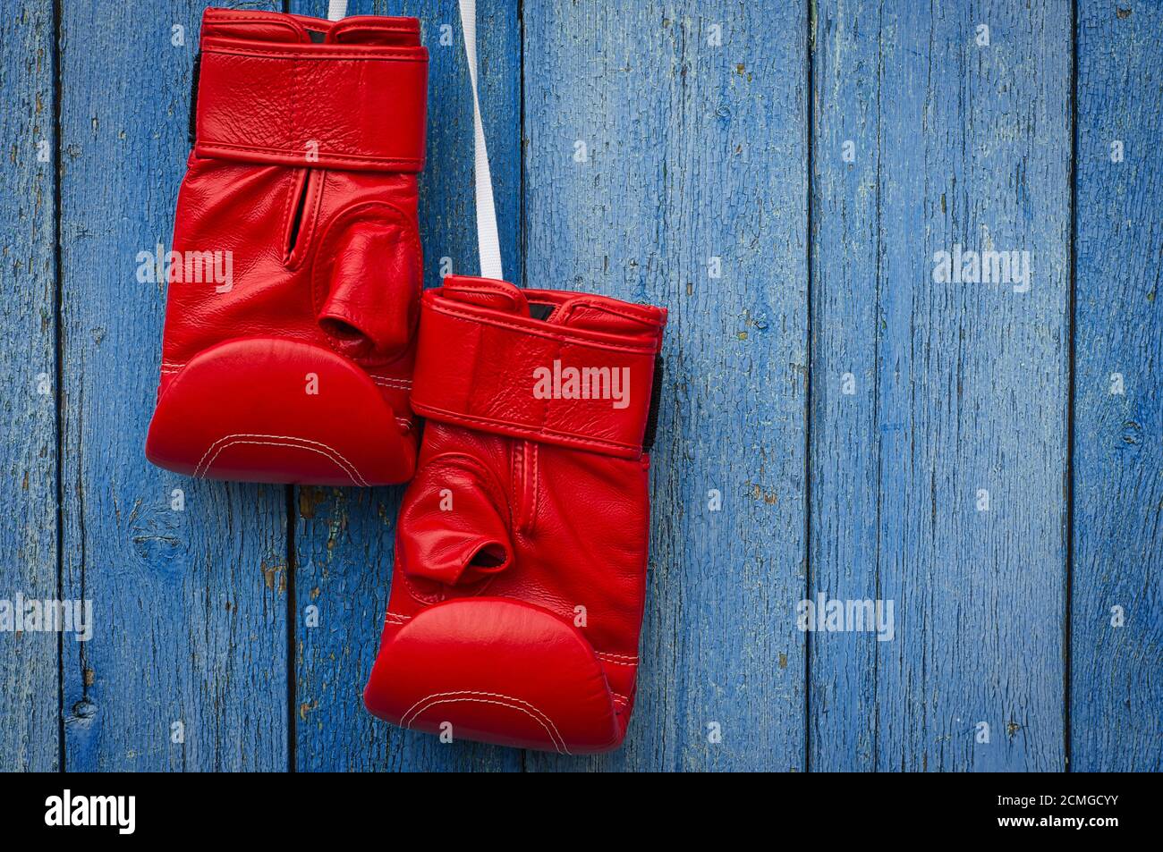 Red leather boxing gloves hanging on a rope Stock Photo Alamy