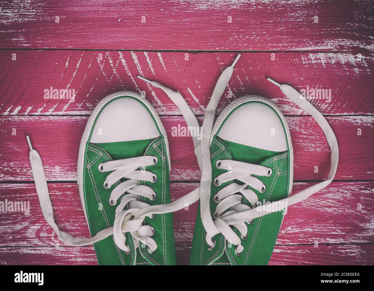 pair of worn sneakers on a pink green old wooden surface Stock Photo ...