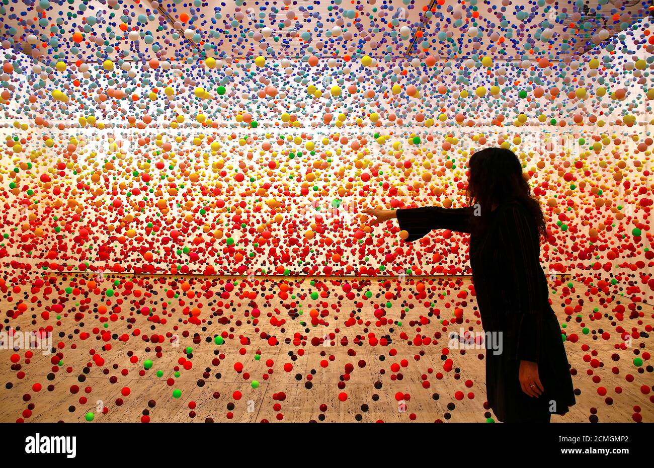 Australian artist Nike Savvas adjusts her installation artwork piece,  consisiting of over 50,000 polystyrene balls, titled 'Atomic: full of love  full of wonder' as it is installed for the upcoming exhibition 'Spacemakers