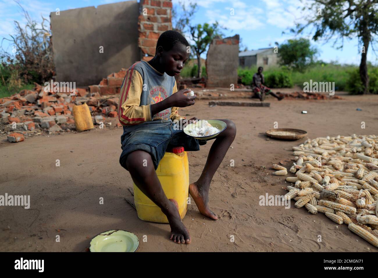 Bernado Jofresse, 14, eats rice for breakfast as he sits beside his family's damaged house in the aftermath of Cyclone Idai, in the village of Cheia, which means 'Flood' in Portuguese, near Beira, Mozambique April 3, 2019. REUTERS/Zohra Bensemra  SEARCH 'BENSEMRA FLOOD' FOR THIS STORY. SEARCH 'WIDER IMAGE' FOR ALL STORIES. Stock Photo