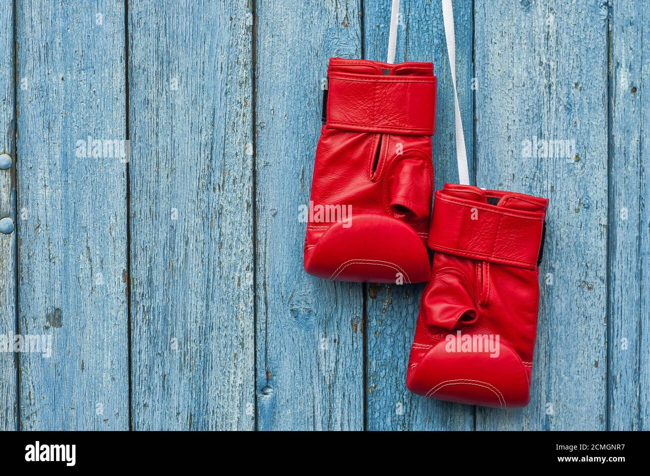 pair of red boxing gloves hanging on a nail Stock Photo Alamy